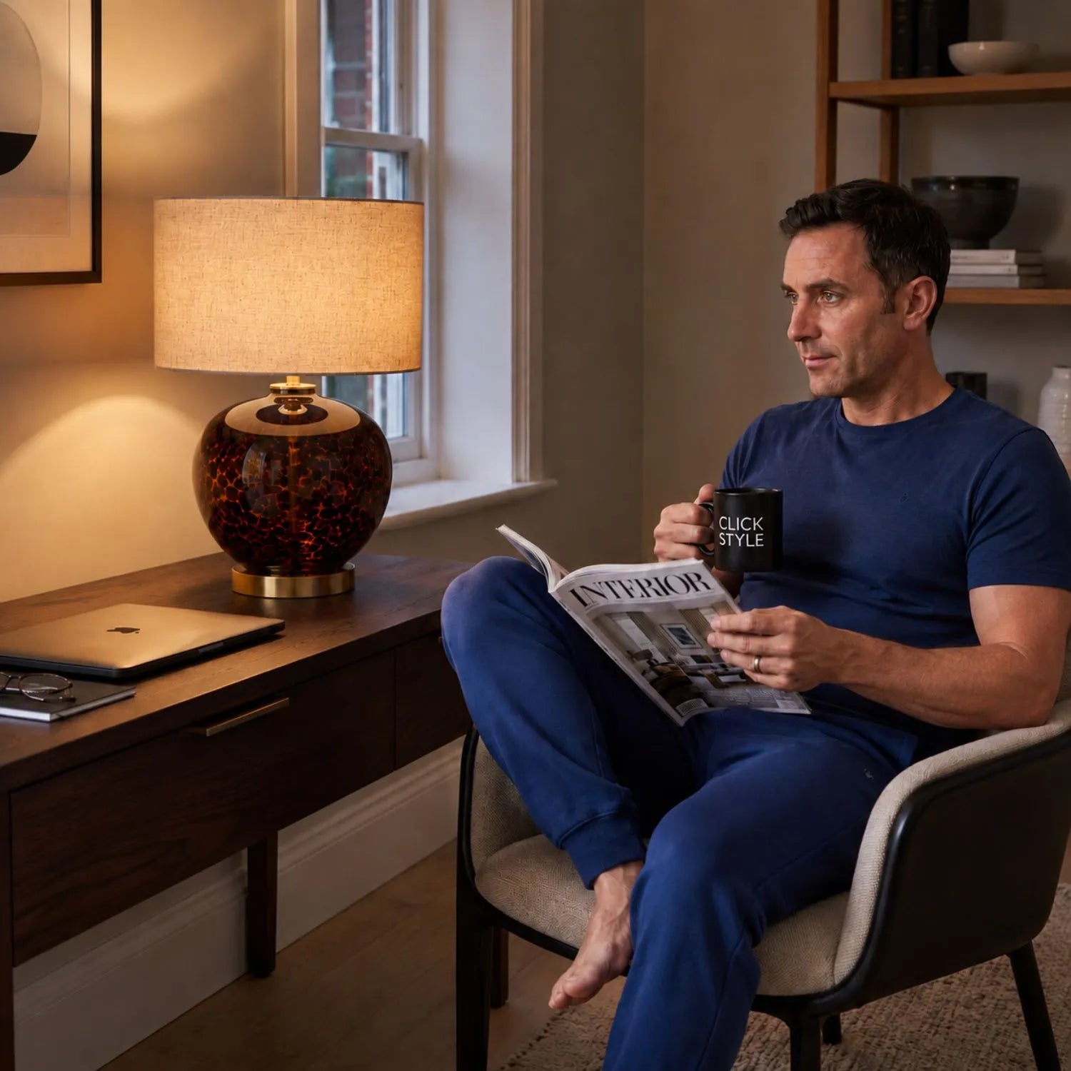 Amber & Brown Tortoiseshell Glass Table Lamp with Natural Linen Shade styled in a contemporary home study with a man relaxing and reading beside the illuminated lamp 44x30x30cm | Click Style