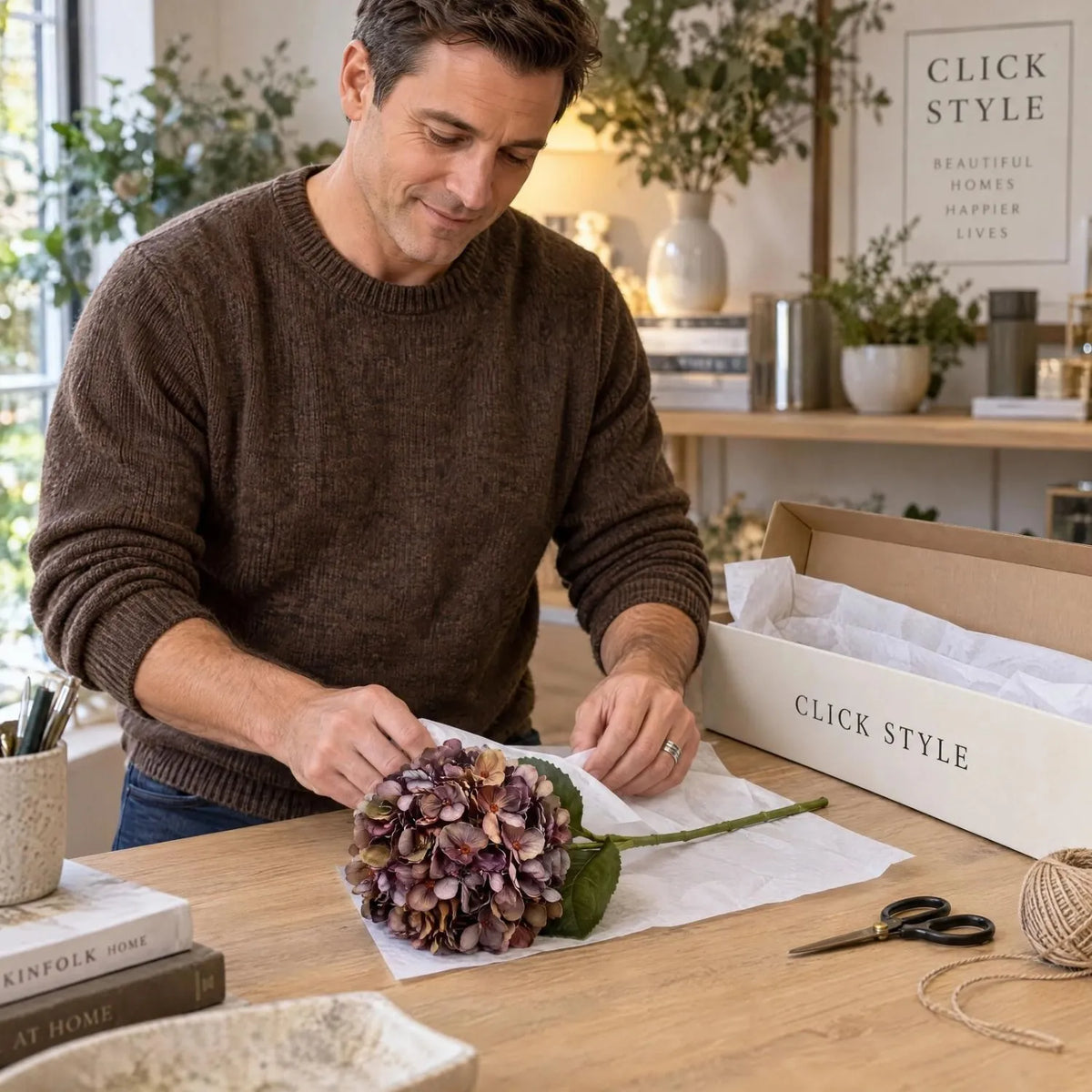Artificial Antique Mauve & Copper Hydrangea Stem with Burgundy Petals & Realistic Green Leaves – Lifelike Faux Brown Hydrangea Flower 42x18x18cm – Single Hydrangea Stem Carefully Wrapped in White Tissue Paper by Man Wearing Brown Wool Jumper with Branded Packaging | Click Style