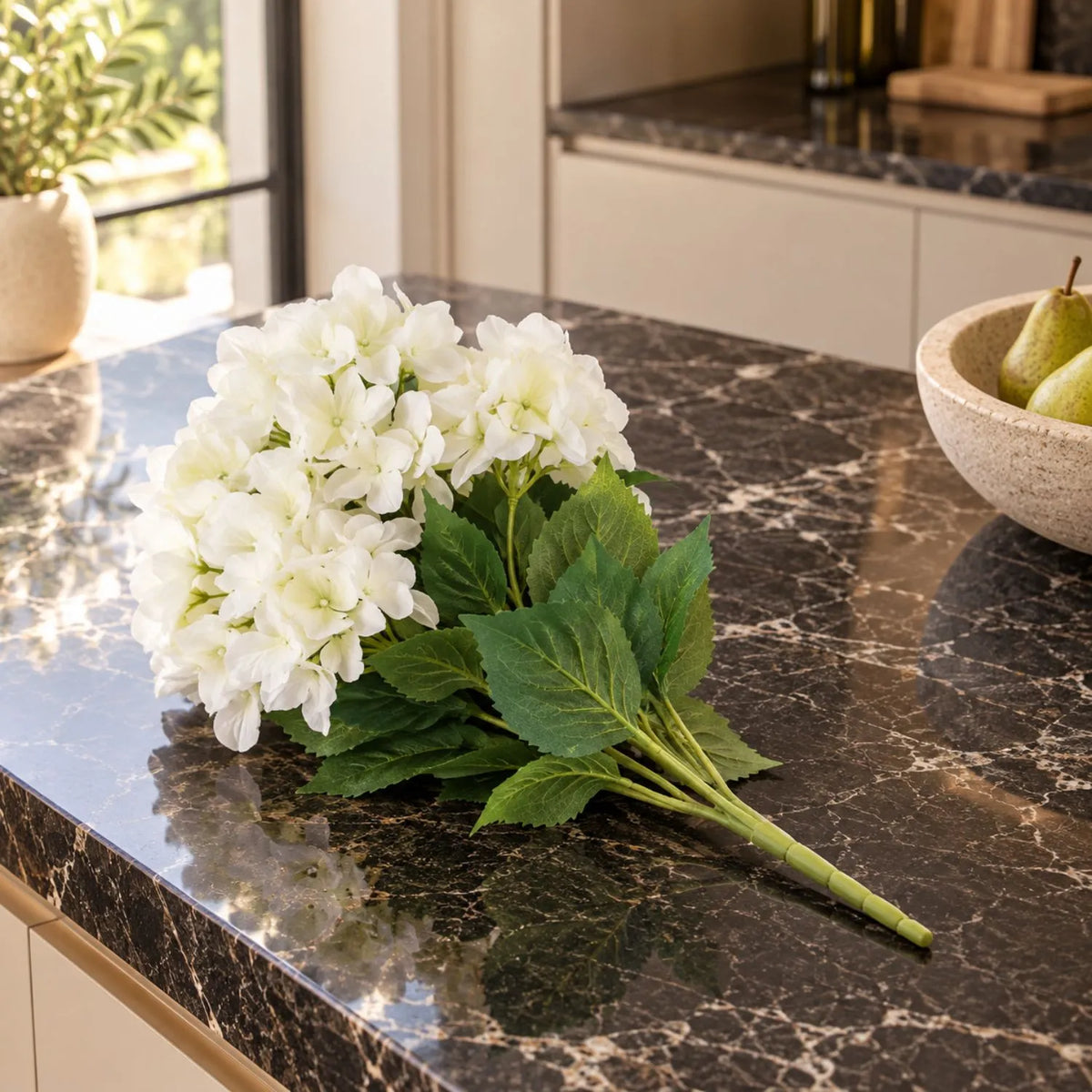 Artificial Creamy White Multi-Bloom Hydrangea Bouquet Stem with Realistic Green Foliage – Lifelike Faux Cream Hydrangea Arrangement 54x34x34cm Lying Flat on Black Marble Kitchen Island Showing Complete Flower Heads Leaves and Stem | Click Style