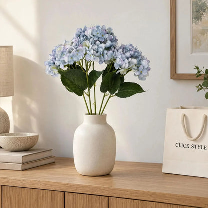Artificial Multi-Tonal Blue Hydrangea Bouquet Stem with Five Flower Heads & Realistic Green Leaves – Faux Blue Hydrangea Flower 47x23x23cm – Blue Hydrangea Arrangement in Cream Ceramic Vase on Oak Sideboard | Click Style