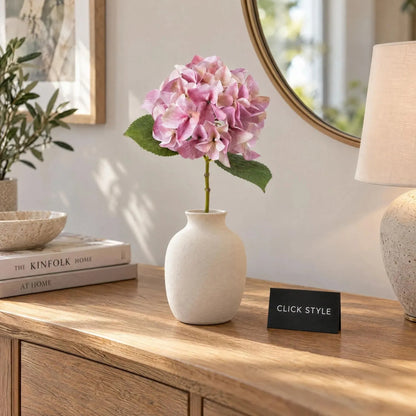 Artificial Pink Hydrangea Stem with Multi-Tonal Petals & Realistic Green Leaves – Lifelike Faux Pink Hydrangea Flower 50x30x30cm styled as a single stem in an ivory ceramic vase on an oak sideboard, featuring soft pink, mauve and cream petals with realistic green foliage in a contemporary living room | Click Style