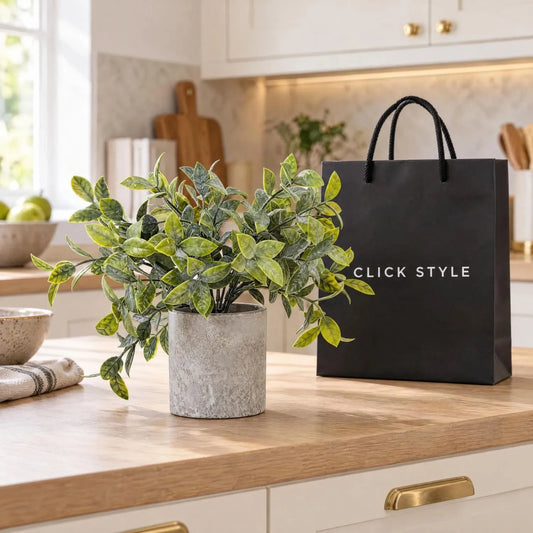 Artificial Small Green Buxus Plant in Grey Stone-Effect Pot with Realistic Green Foliage – Lifelike Faux Box Plant 20cm displayed on a light oak kitchen worktop in a contemporary cream kitchen beside a black shopping bag with white CLICK STYLE branding | Click Style