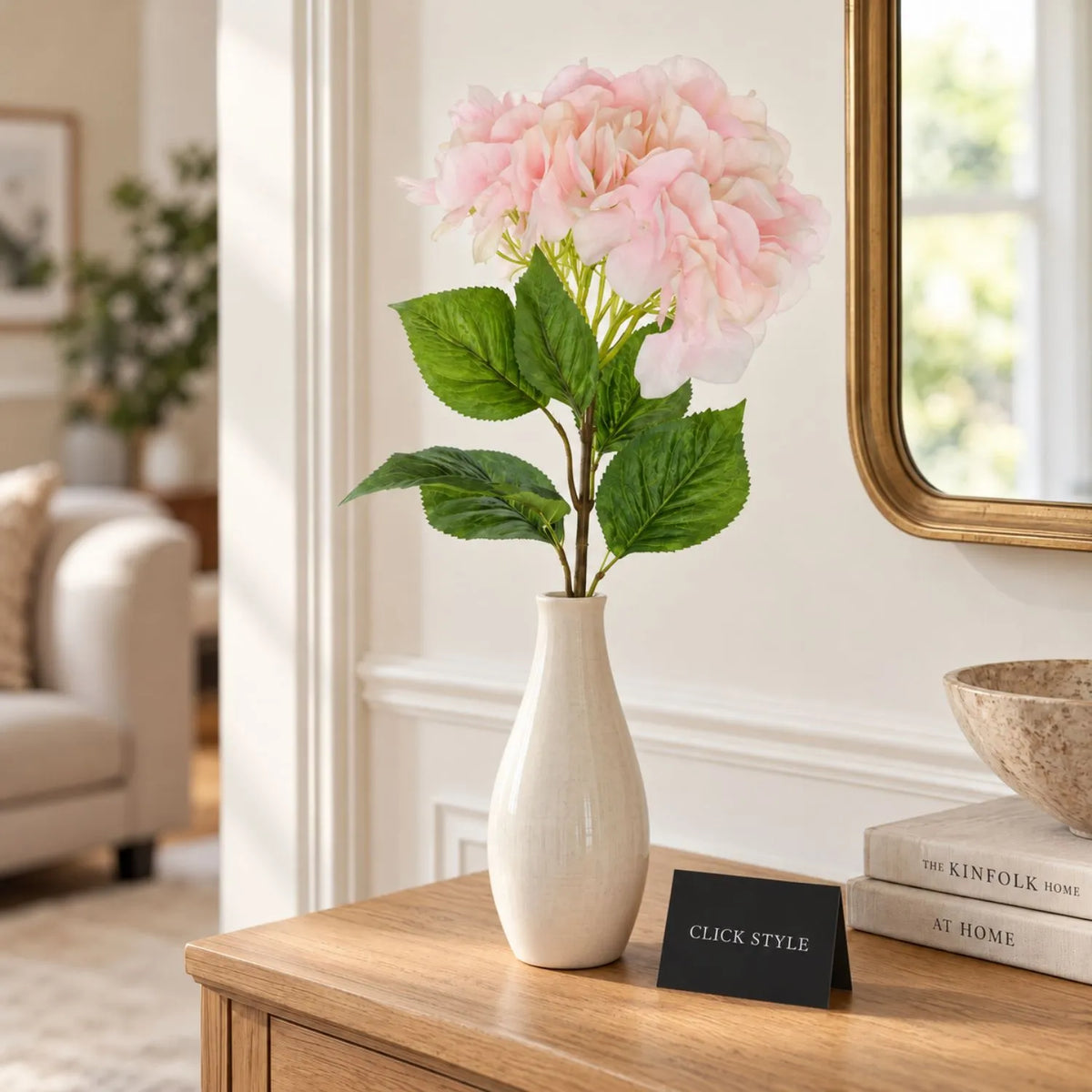 Artificial Soft Pink Long Stem Hydrangea with Full Rounded Flower Head & Realistic Green Leaves – Lifelike Pink Faux Hydrangea Flower 70cm styled as a single stem in an ivory ceramic vase on a natural oak console table in a contemporary neutral living room | Click Style