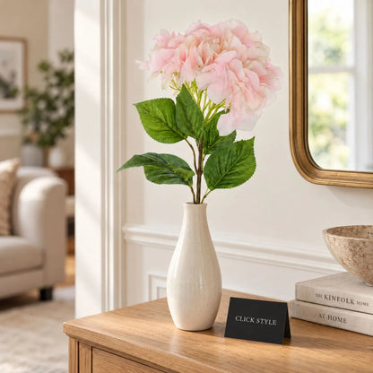 Artificial Soft Pink Long Stem Hydrangea with Full Rounded Flower Head & Realistic Green Leaves – Lifelike Pink Faux Hydrangea Flower 70cm styled as a single stem in an ivory ceramic vase on a natural oak console table in a contemporary neutral living room | Click Style