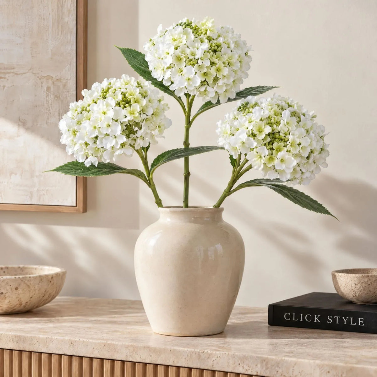 Artificial White Mophead Hydrangea Stem with Full Rounded Bloom & Realistic Green Foliage – Lifelike Faux White Hydrangea Flower 48cm – Three artificial white hydrangea stems arranged in a cream vase with full rounded blooms and realistic green leaves | Click Style