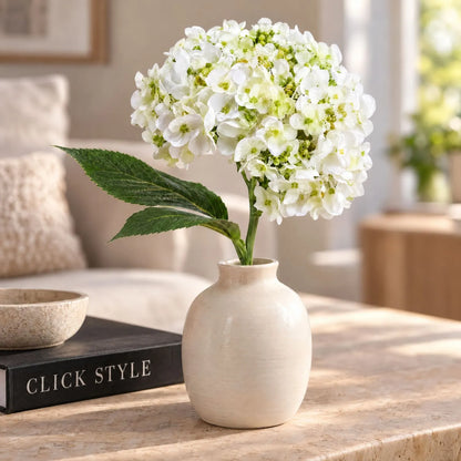 Artificial White Mophead Hydrangea Stem with Full Rounded Bloom & Realistic Green Foliage – Lifelike Faux White Hydrangea Flower 48cm – Single white hydrangea displayed in a cream ceramic vase on a stone console table | Click Style