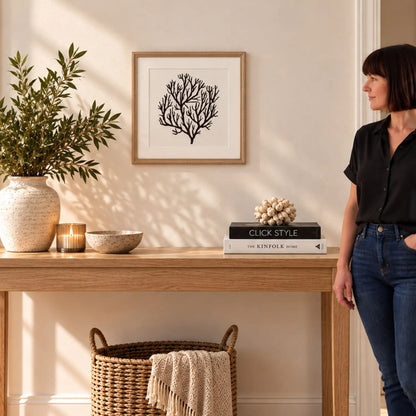 Black & White Coral Print Artwork with Natural Brown Beaded Wooden Frame – Square Full Coral Design 40x40cm styled above a natural wood console with woman viewing the artwork | Click Style