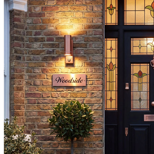 Brushed Copper Outdoor Up & Down PIR Motion Sensor Wall Light Illuminating an Exterior Wall with Dual Up and Down Light Beams | Click Style