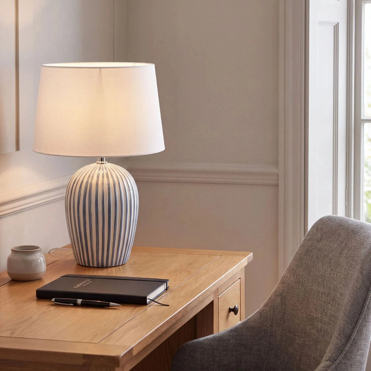 Denim Blue & White Striped Ceramic Table Lamp with White Cotton Tapered Shade – Ribbed Bulbous Base Bedside Light 45x30x30cm styled on a wooden desk in a contemporary home office | Click Style