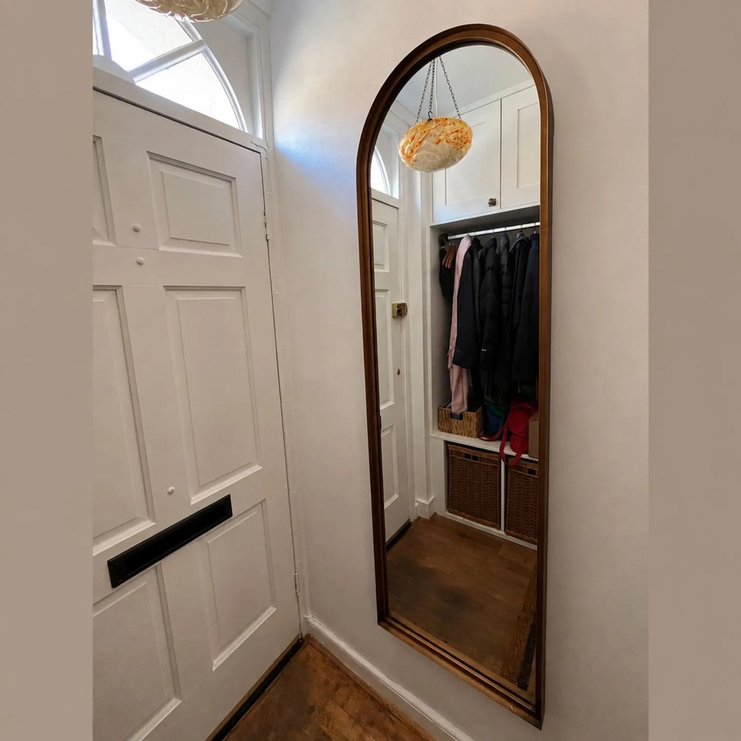 Full Length Aged Bronze Channel Frame Arched Wall Mirror beside a white front door in a customer hallway | Click Style