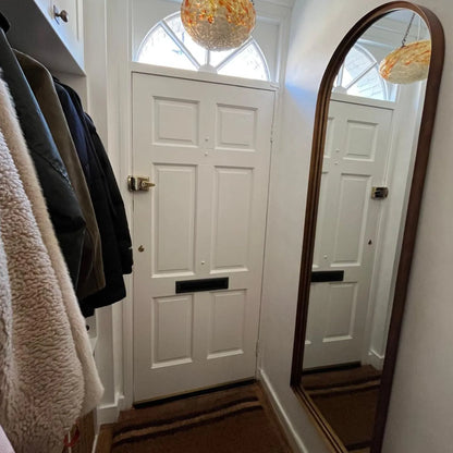 Full Length Aged Bronze Channel Frame Arched Wall Mirror beside a white front door in a customer hallway | Click Style