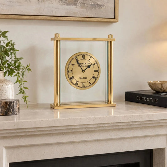 Gold Metal & Glass Table Mantel Clock with Floating Clock Face Roman Numerals & Black Hands 28x25x7cm styled on a stone mantelpiece with Click Style book | Click Style