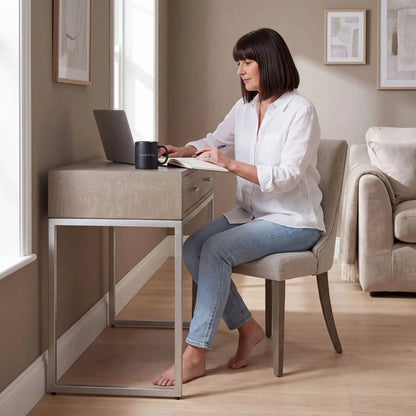 Grey Wash Mango Wood 2 Drawer Dressing Table & Desk with Silver Metal Handles & Legs used as a home office desk with woman working on laptop | Click Style