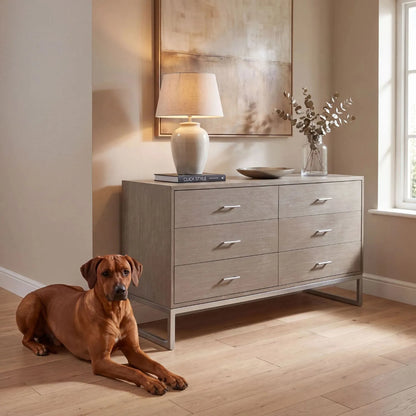 Grey Wash Mango Wood 6 Drawer Chest of Drawers with Silver Metal Handles & Legs 73x130x49cm styled in a warm neutral interior with Rhodesian Ridgeback | Click Style