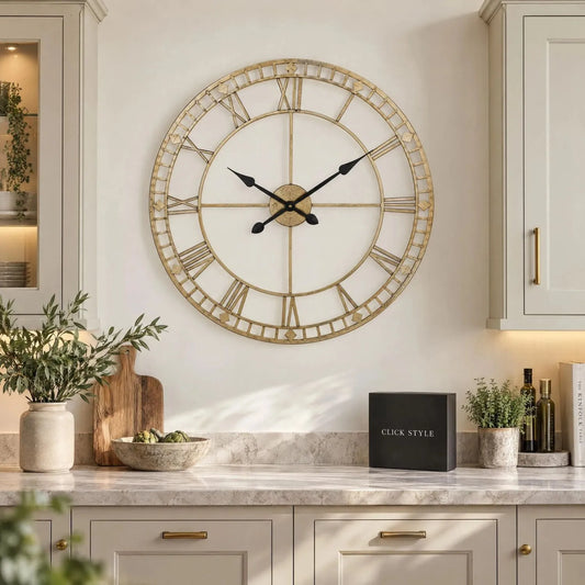 Large Antique Gold Metal Skeleton Wall Clock with Roman Numerals & Black Hands – Round Open Frame Design 80x80x5cm displayed in a contemporary cream kitchen above a marble-effect worktop with black and white CLICK STYLE branding | Click Style