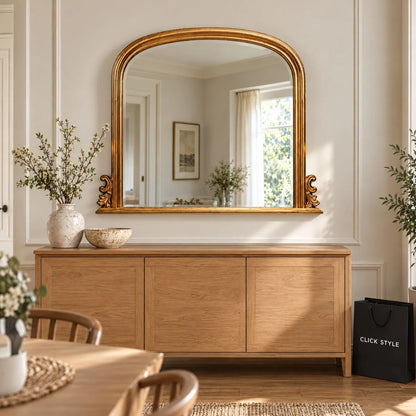 Large Antique Gold Overmantel Mirror with Arched Top & Ornate Scrollwork – Bevelled Glass Gold Leaf Effect Mantle Mirror 94x118x6cm mounted above a natural oak sideboard in a contemporary dining room with neutral walls, decorative ceramics and soft natural daylight | Click Style