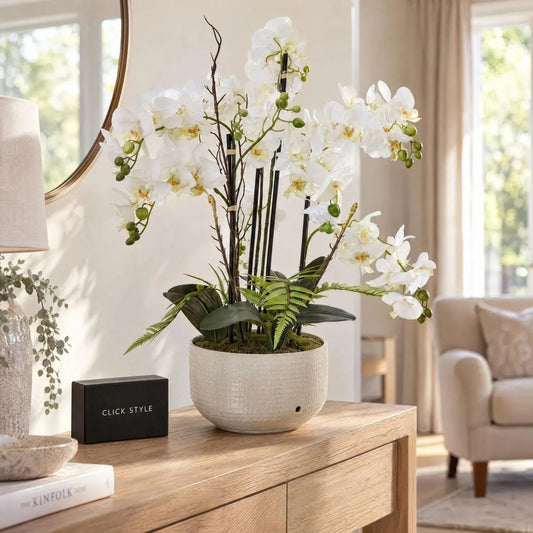 Large Artificial White Phalaenopsis Orchid Plant with Fern Foliage & Decorative Branches in Textured Light Stone Glazed Ceramic Pot – Realistic Potted Faux Orchid Arrangement 76x65x60cm displayed on a natural oak console table in a bright neutral living room with black CLICK STYLE branding | Click Style