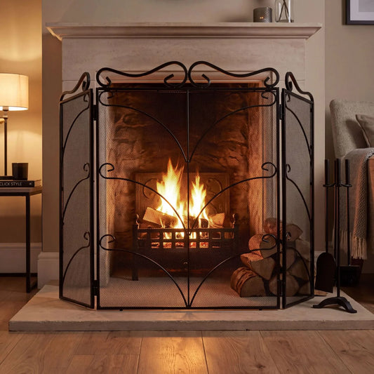 Large Ornate Black Metal Firescreen with Scrollwork – Decorative Fire Guard 75x85x2cm in front of a glowing fireplace