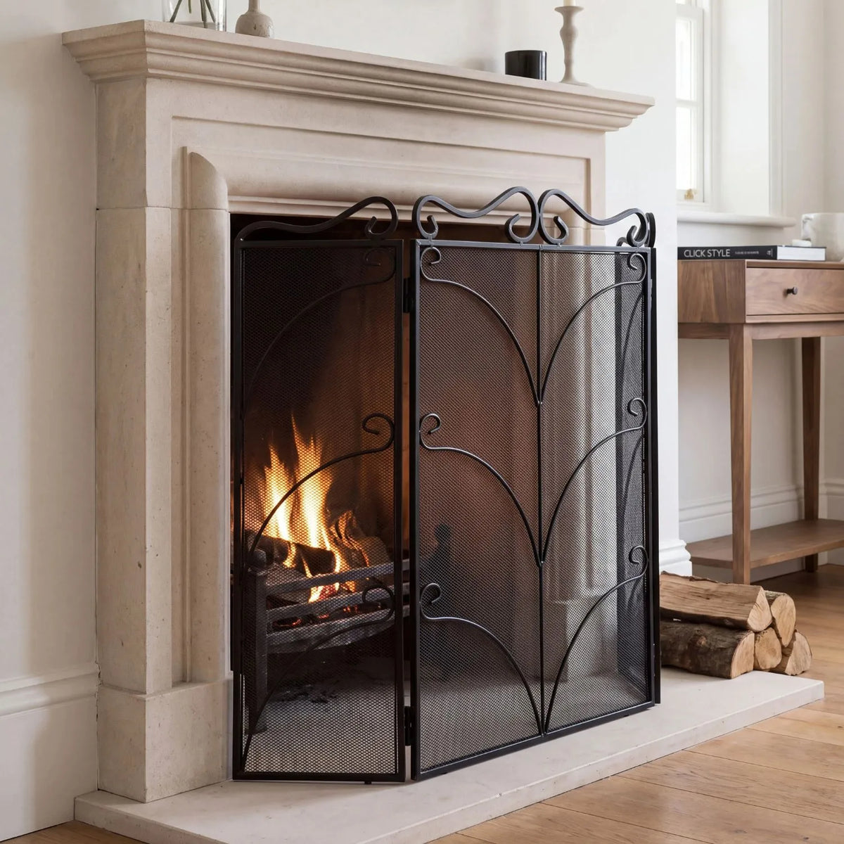 Large Ornate Black Metal Firescreen with Scrollwork – Decorative Fire Guard 75x85x2cm shown at an angle on a stone hearth