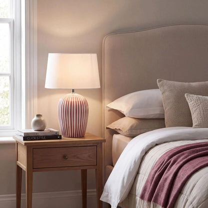 Mulberry Red & White Striped Ceramic Table Lamp with White Cotton Tapered Shade – Ribbed Bulbous Base Bedside Light 45x30x30cm illuminated on wooden bedside table in neutral bedroom | Click Style