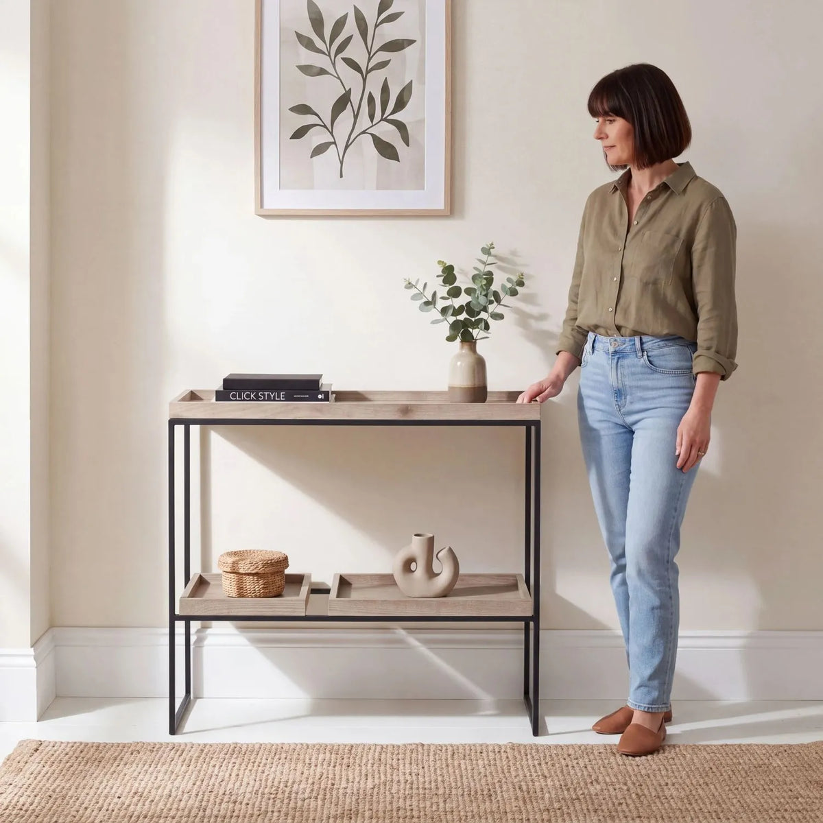 Natural Wood Effect Veneer 2 Shelf Display Unit with 3 Trays & Black Metal Frame styled with woman in a modern home | Click Style