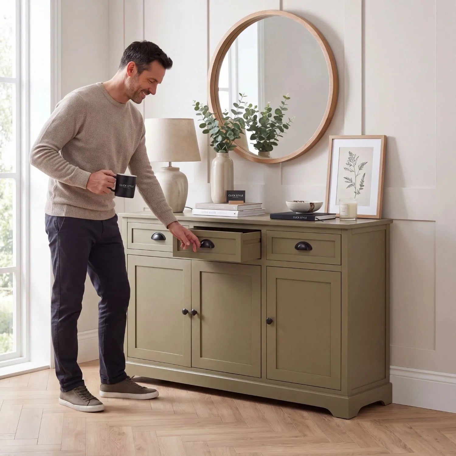 Olive Green Pine Wood 3 Door 3 Drawer Sideboard with Matt Black Cup Handles styled in a modern country home with a man opening a drawer and holding a Click Style mug 75x120x35cm | Click Style