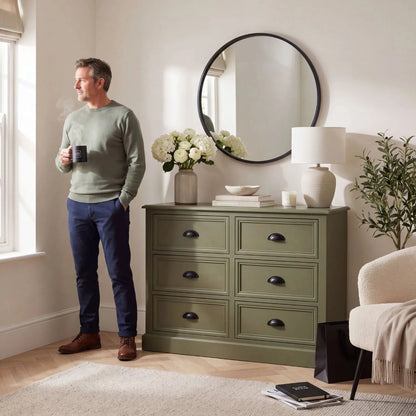 Olive Green Pine Wood 6 Drawer Chest of Drawers with Matt Black Cup Handles Styled in a Modern Country Living Room with Man Holding a Cup of Tea | Click Style