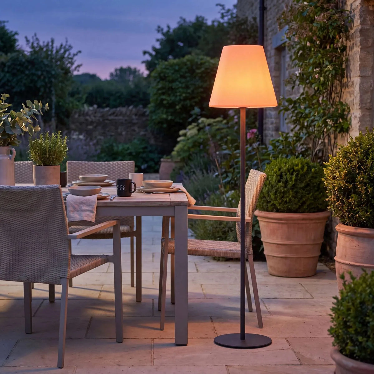 Outdoor Grey Rechargeable LED Floor Lamp with Dimmable & Colour-Changing Settings – Weather-Resistant Garden Light 153x35x35cm glowing warm peach in a contemporary outdoor dining terrace at dusk | Click Style