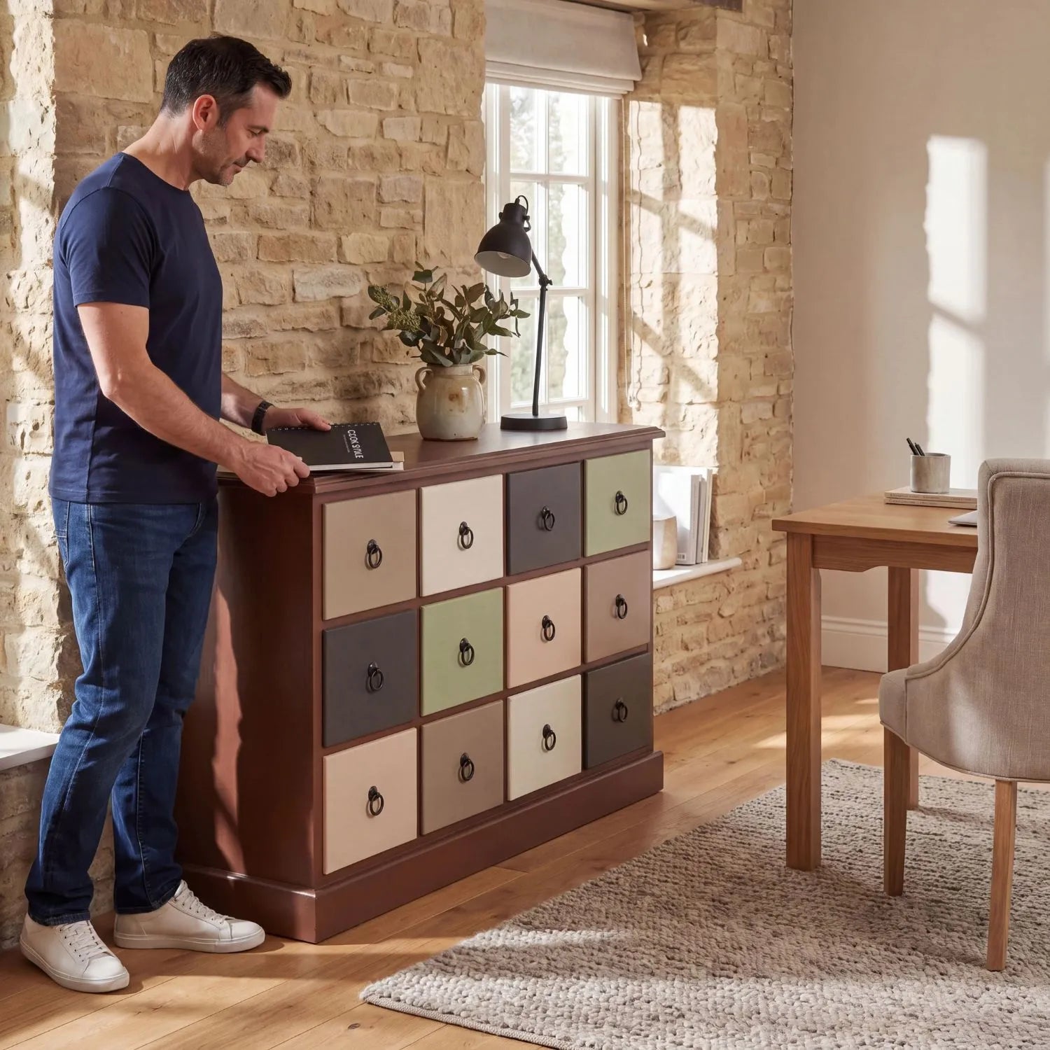 Sage Green & Neutral Pine Wood 12 Drawer Storage Chest with Black Ring Handles styled in a contemporary home office with man | Click Style