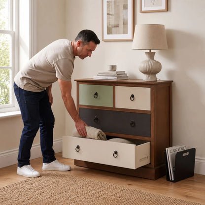 Sage Green & Neutral Pine Wood 4 Drawer Chest with Black Ring Handles with man placing a folded throw into the lower drawer | Click Style