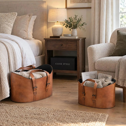 Set of Two Light Brown Leather Storage Baskets with Carry Handles & Buckle Straps – Sculptural Storage Bins 34x50x40cm Styled in Bedroom with Bed & Armchair | Click Style