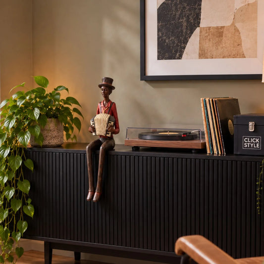 Shelf-Sitter Jazz Accordionist Resin Ornament – Sitting Musician Sculpture 40x12x10cm Styled on Black Ribbed Sideboard in Contemporary Listening Room | Click Style