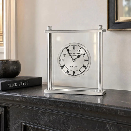 Silver Metal & Glass Table Mantel Clock with Floating Clock Face Roman Numerals & Black Hands 28x25x7cm styled on a dark charcoal mantelpiece with Click Style book | Click Style