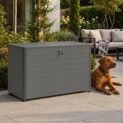 Small Anthracite Grey Galvanised Steel Outdoor Cushion Storage Box with Lockable Lid styled in a garden with dog lying beside it and throw on outdoor settee 78x134x62cm | Click Style