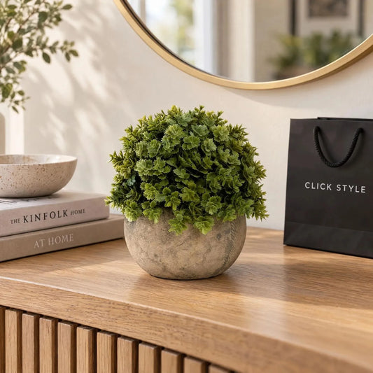 Small Artificial Green Hebe Veronica Plant with Dense Bushy Foliage in Weathered Stone-Effect Pot – Realistic Faux Potted Greenery 13x13x13cm displayed on a light oak console table beneath a round gold mirror beside a black CLICK STYLE shopping bag | Click Style