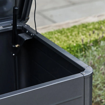 Small Black Galvanised Steel Outdoor Cushion Storage Box lifestyle image from front right with open lid showing gas piston and rounded front edge | Click Style