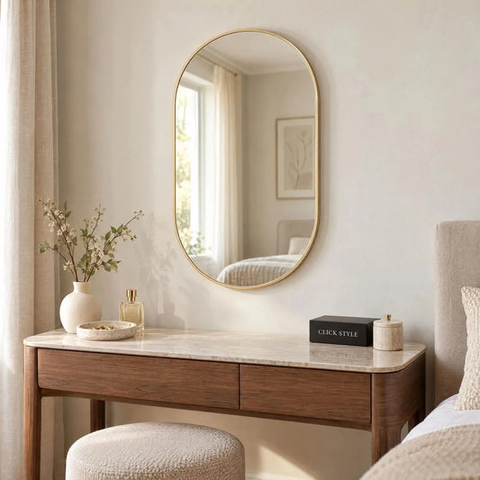 Small Champagne Gold Racetrack Oval Wall Mirror with Slim Metal Frame – Contemporary Pill Shaped Mirror 75x50x4cm displayed above a walnut dressing table with pale stone top in a contemporary bedroom | Click Style