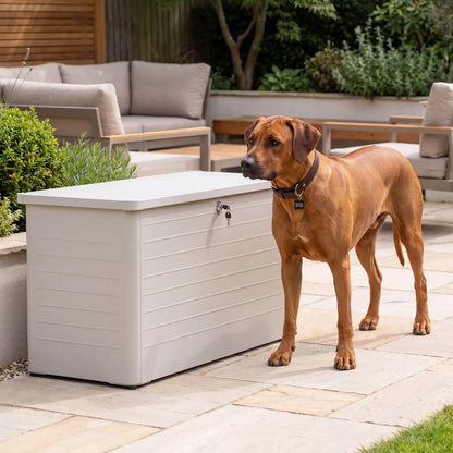 Small Light Grey Pebble Galvanised Steel Outdoor Cushion Storage Box with closed lid and Rhodesian Ridgeback dog styled in a contemporary garden with Click Style branding | Click Style
