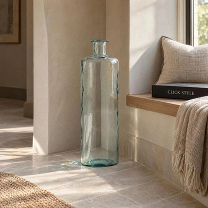 Tall Clear Recycled Glass Bottle Vase with Narrow Neck – Large Decorative Floor Standing Vase 75x25x25cm – Displayed Empty Beside a Window Seat in a Warm Neutral Interior | Click Style
