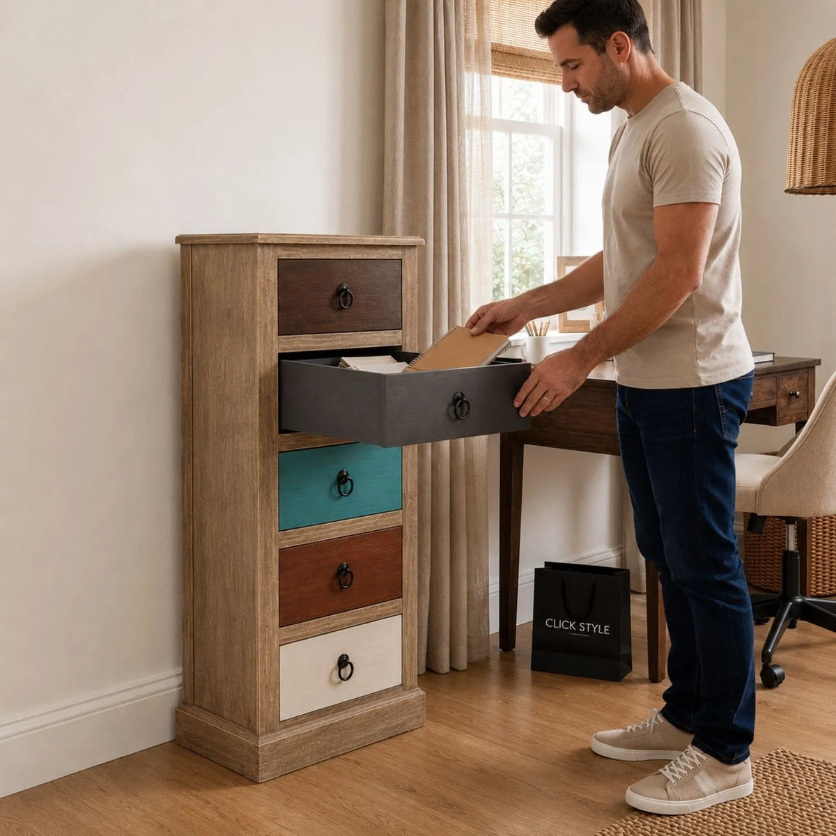 Turquoise blue and neutral distressed pine wood 5 drawer tallboy chest with black ring handles styled in a home office with man | Click Style