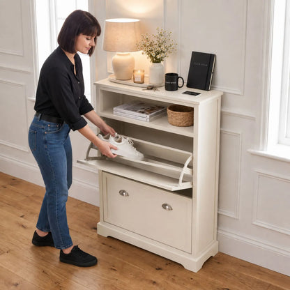 Warm Ivory Pine Wood 2 Drawer Shoe Storage Unit with Silver Cup Handles with a woman putting white trainers into the open shoe rack 106x80x28cm | Click Style