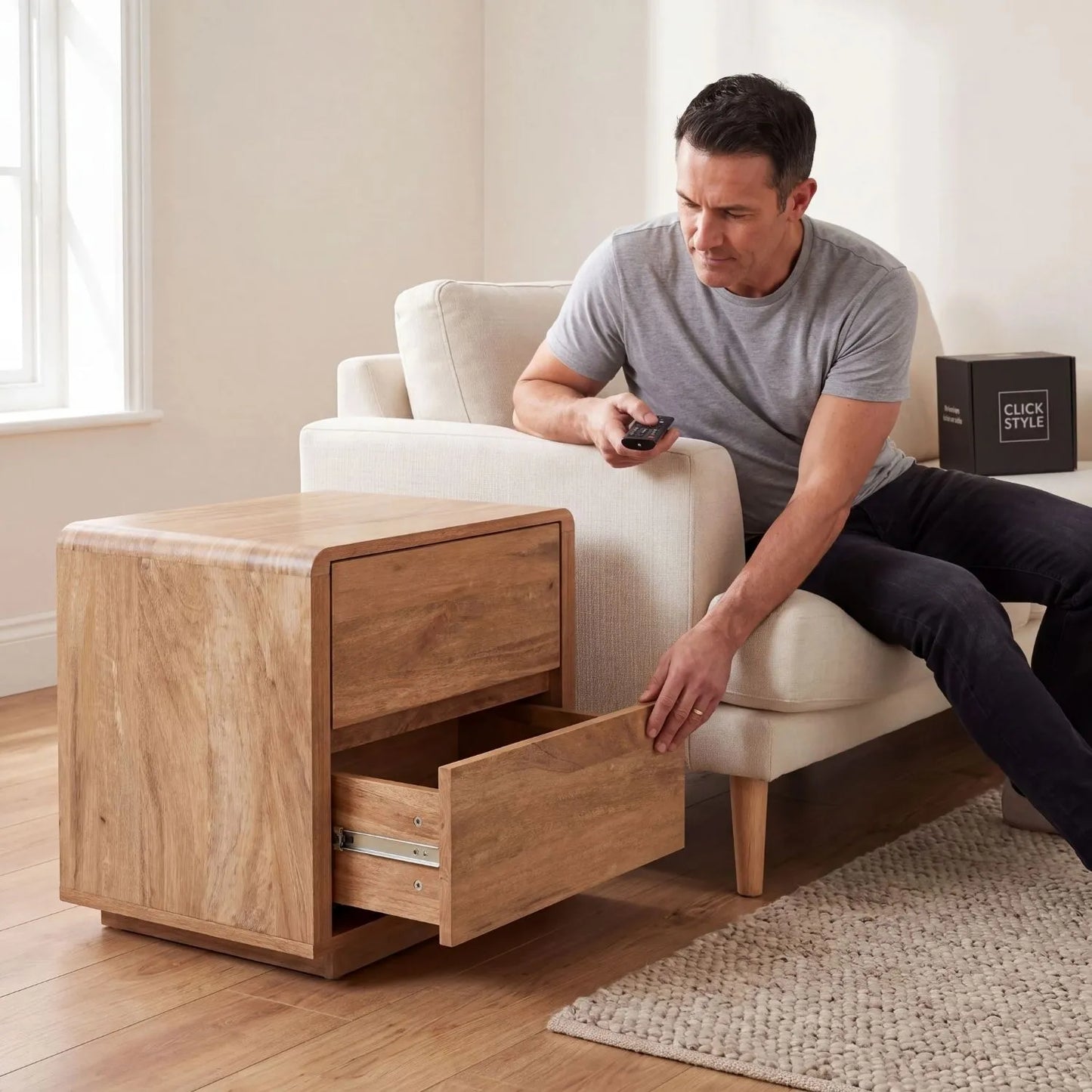 Warm Natural Oak Effect Side Table & Bedside Table with 2 Handleless Drawers used by man beside a neutral armchair in a living room | Click Style