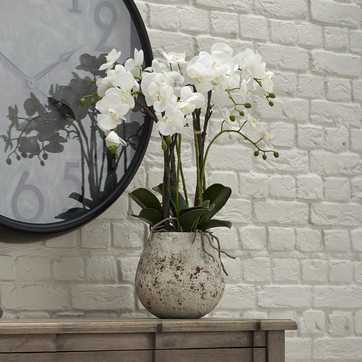 Artificial large white orchid in a stone pot