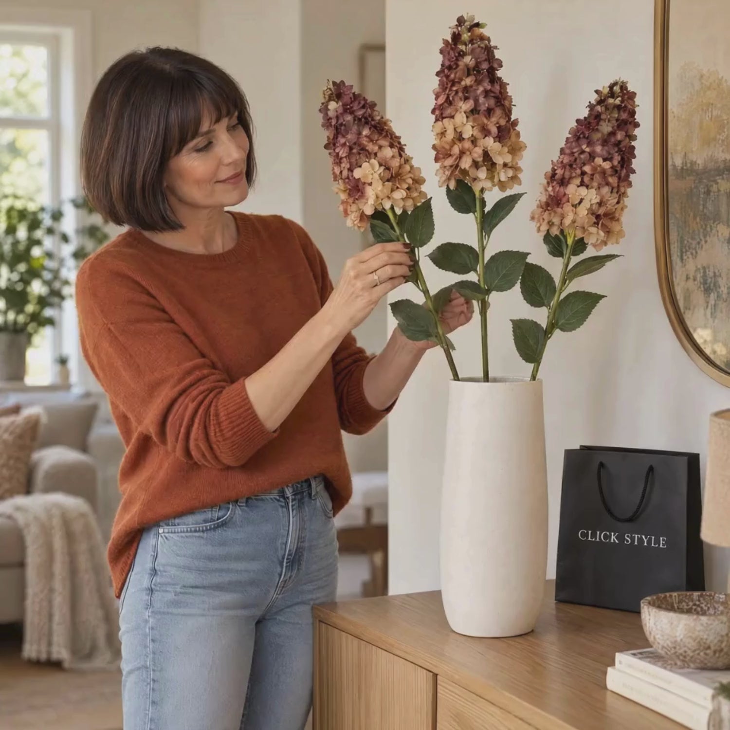 Artificial Burgundy & Peach Long Stem Spear Hydrangea with Realistic Green Leaves – Three Faux Hydrangea Stems in Cream Vase with Woman Gently Adjusting Foliage – Lifestyle Video | Click Style