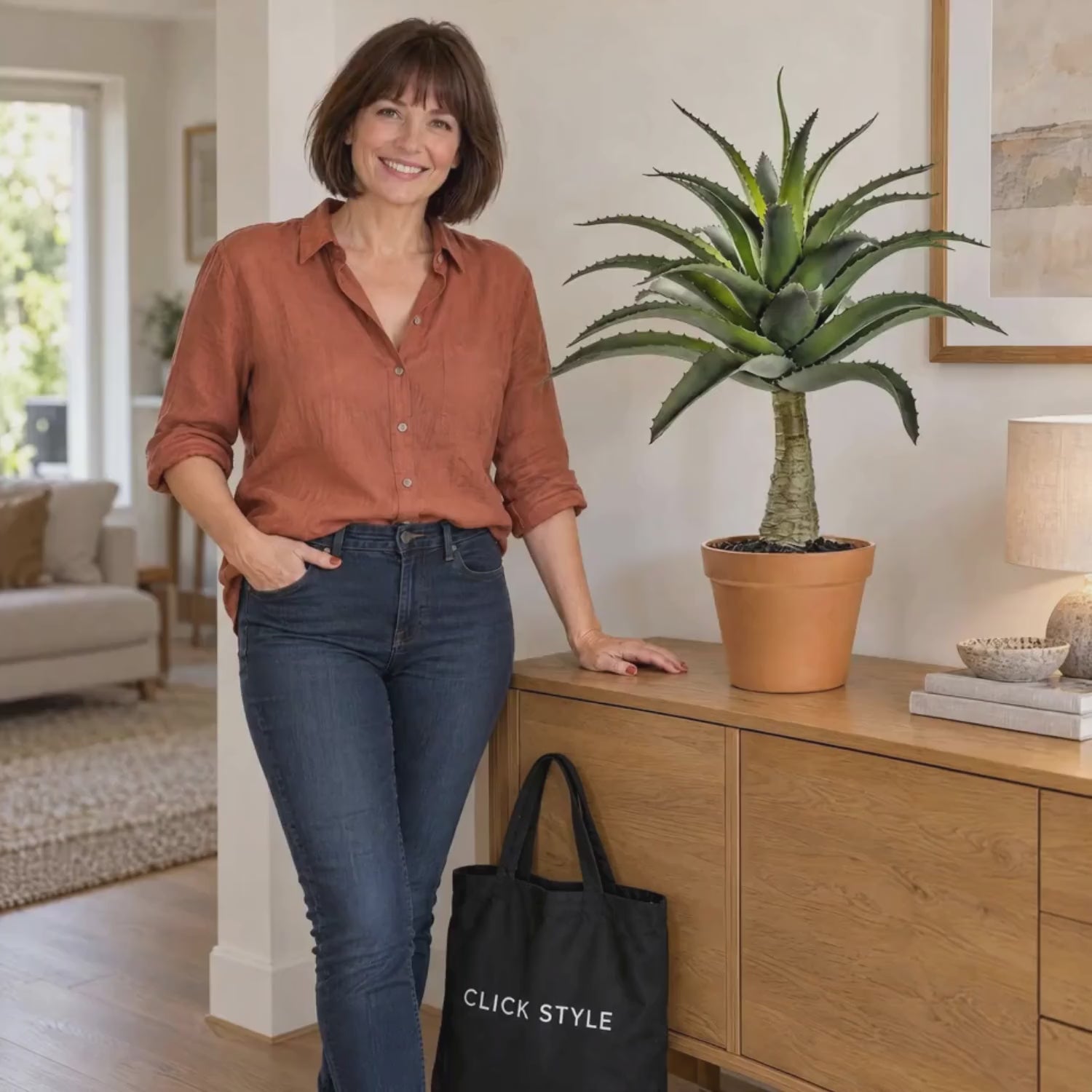 Artificial Green Agave Succulent Plant with Spiky Leaves & Textured Trunk in Terracotta Coloured Pot – Realistic Potted Faux Desert Plant 57x43x43cm shown in a lifestyle video with a woman gently touching an outer leaf beside a black CLICK STYLE branded tote bag | Click Style